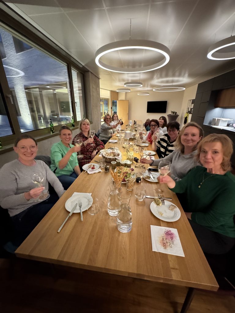 Teilnehmer der Sektprobe am Tisch sitzend und zuprostend