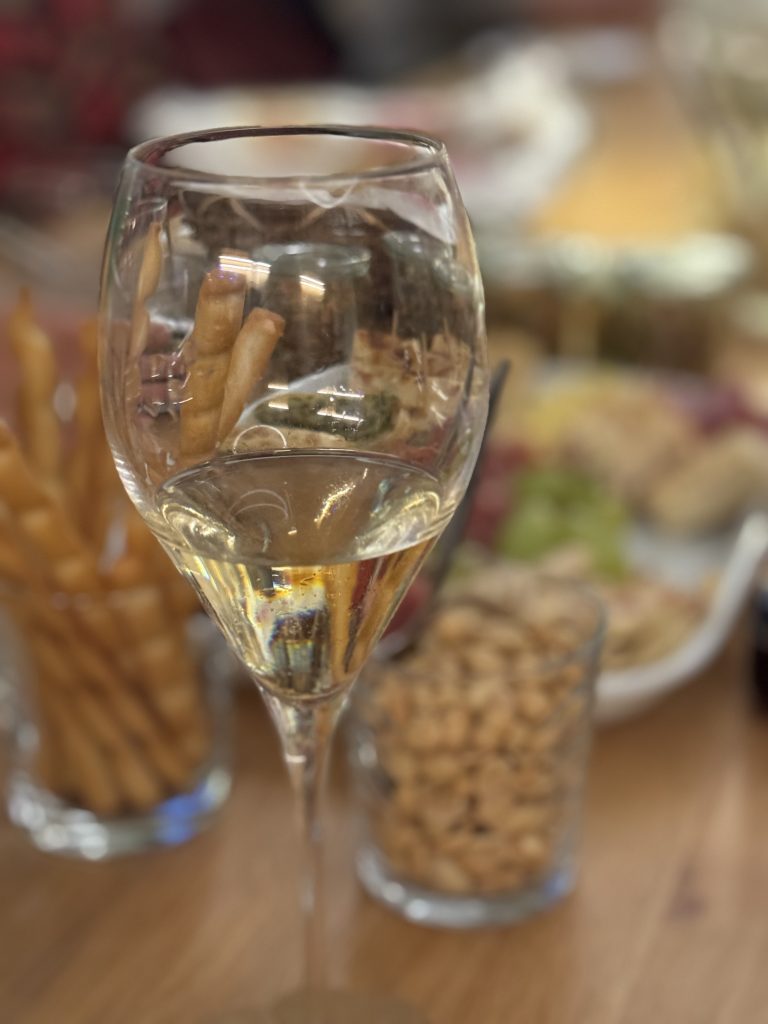 Stilleben gefülltes Sektglas mit Fingerfood im Hintergrund